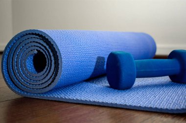 Spor salonunda halter ile Mavi yoga mat 