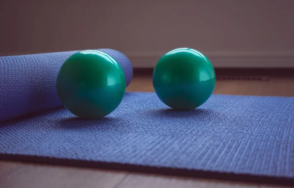 Yoga mat and balls with pastel background