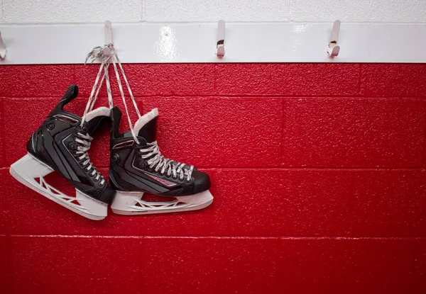 Patins Hóquei Pendurados Vestiário Sobre Fundo Vermelho Com Espaço Cópia — Fotografia de Stock