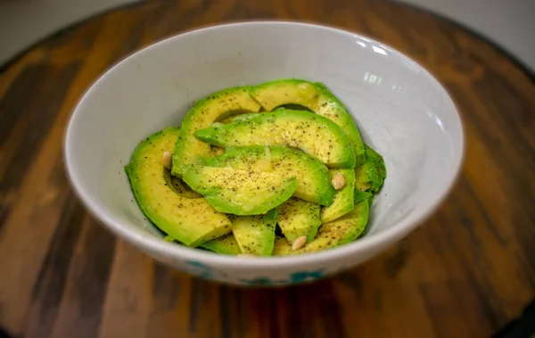 Cuenco Aguacate Fresco Rodajas Sobre Mesa Madera Con Fondo Borroso —  Fotos de Stock