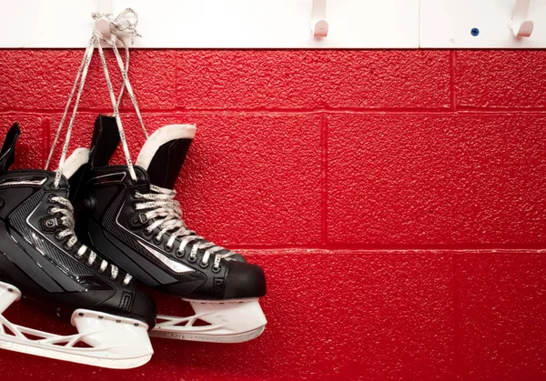 Hokey paten kırmızı arka planda kopya alanı ile soyunma odasında asılı 
