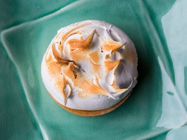 Kare seramik tabak üst görünümünde limon beze pasta 