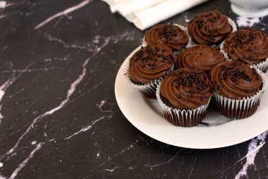 Kopya alanı ile beyaz plaka ve siyah mermer arka plan üzerinde Çikolata cupcakes