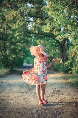 Sunset Bulvarında doğa şehir dışında bir yaz akşamında ışınları içinde pembe şapkalı güzel bir kız.
