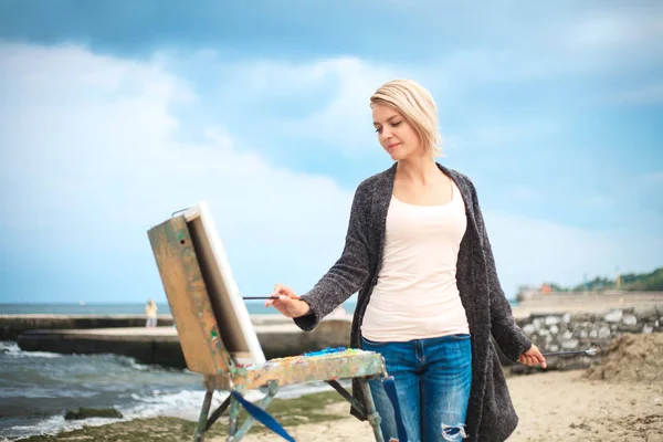 海と空を背景に美しい若い女性の絵画 創造性の概念屋外で画家の美しい肖像画 — ストック写真