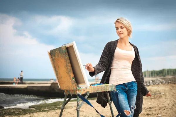 海と空を背景に美しい若い女性の絵画 創造性の概念屋外で画家の美しい肖像画 — ストック写真