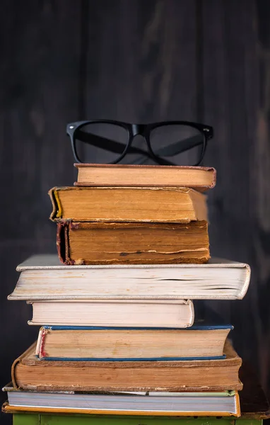 Pilha Livros Capa Dura Com Óculos Leitura Fundo Madeira Escura — Fotografia de Stock