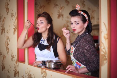 İki kadın mutfakta hazırlamak ve yemeklerin tadına. Retro tarzı. Ev kavramı.