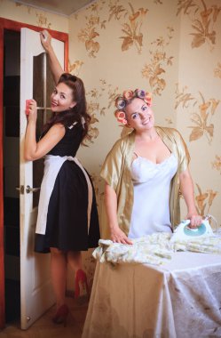 İki kadın ev ödevi yapmak: Ütü ve temizleme. Retro tarzı, vintage