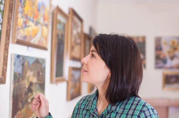 一个年轻的美女在美术馆看绘画 — 图库照片