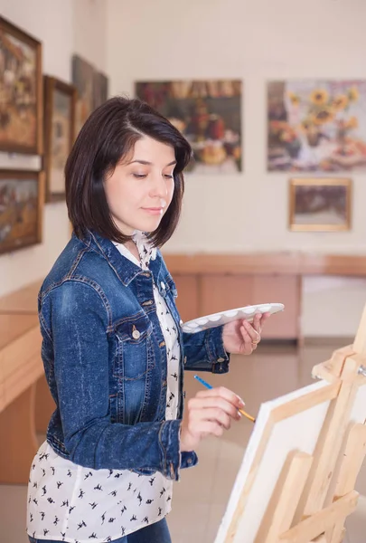 Милая Молодая Женщина Рисует Картину Возле Мольберта Творческой Студии — стоковое фото