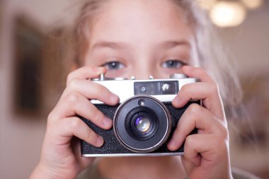 Kız retro bir kamera ile fotoğrafını vurdu studio yapar, yakın çekim.