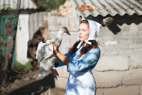 カントリー スタイルに身を包んだ村の女性は ガチョウを保持しています レトロなスタイルでの撮影 — ストック写真