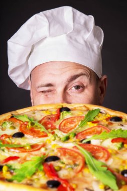 Portre Studio bir pizza ile mutlu çekici Cook bir siyah bir arka plan