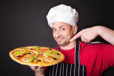 Portre Studio bir pizza ile mutlu çekici Cook bir siyah bir arka plan