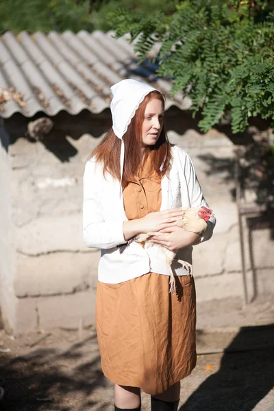 カントリー スタイルに身を包んだ村の女性は 鶏を保持しています レトロなスタイルでの撮影 — ストック写真