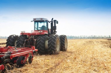 Modern tractor in the field during planting. The concept of agricultural industry. Copy space. clipart