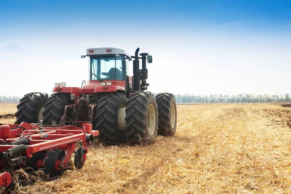 Modern tractor in the field during planting. The concept of agricultural industry. Copy space.