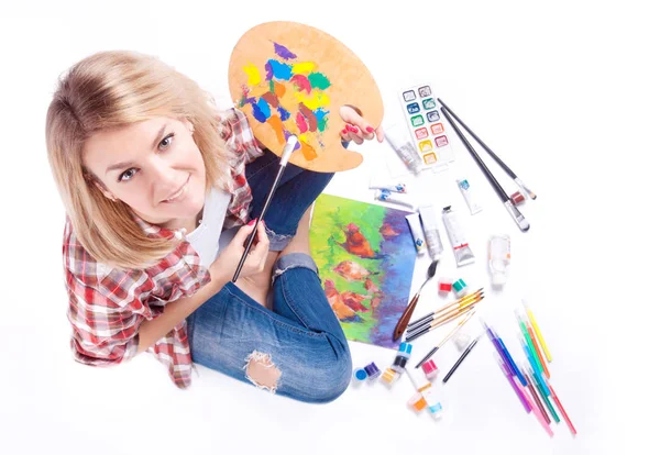 Top view of woman holds in her hands a palette around paint and materials for creativity. — Stock Photo, Image