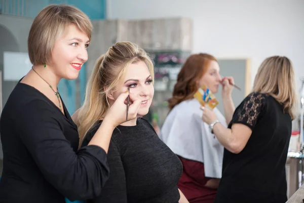 Artista trucco professionale che lavora su giovane ragazza fa il trucco nel salone di bellezza — Foto Stock