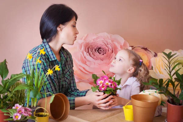 Menina bonito ajuda sua mãe a cuidar de plantas. — Fotografia de Stock
