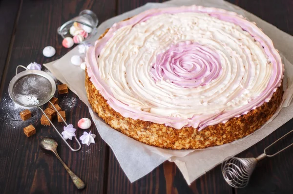 Roze taart met bessen en meringue op de keuken tafel. — Stockfoto