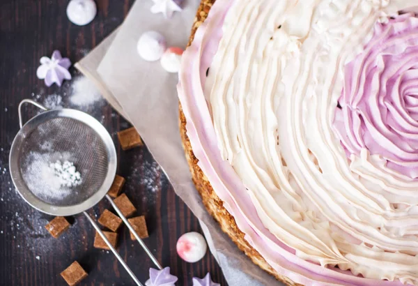 Rosa Kuchen mit Beeren und Baiser auf dem Küchentisch. — Stockfoto