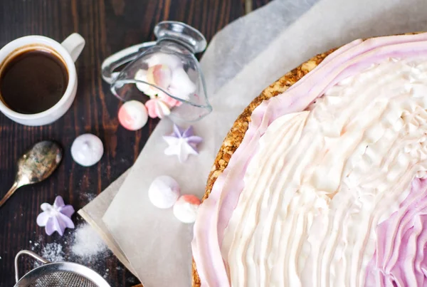 Roze taart met bessen en meringue op de keuken tafel. — Stockfoto