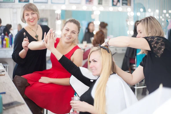 Due amiche in un salone di bellezza dal parrucchiere e un maestro di trucco . — Foto Stock