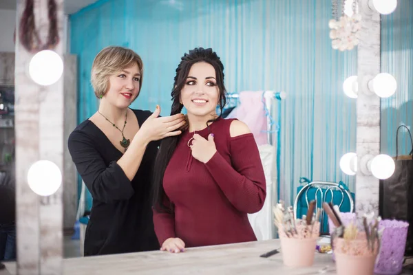 İki güzel genç kadın güzellik salonunda aynaya bakmak. Saç ve makyaj.