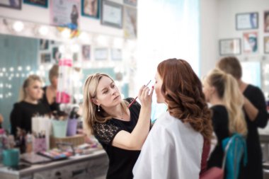 Genç kız çalışma profesyonel makyöz makyaj güzellik salonunda yapar.