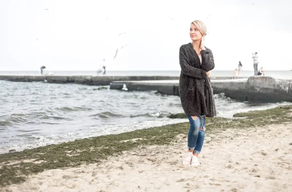 Atraktivní žena nosí teplý svetr v chladné beach. Burzovní obrázek. — Stock fotografie