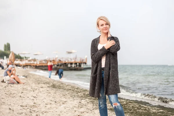 Atraktivní žena nosí teplý svetr v chladné beach. — Stock fotografie