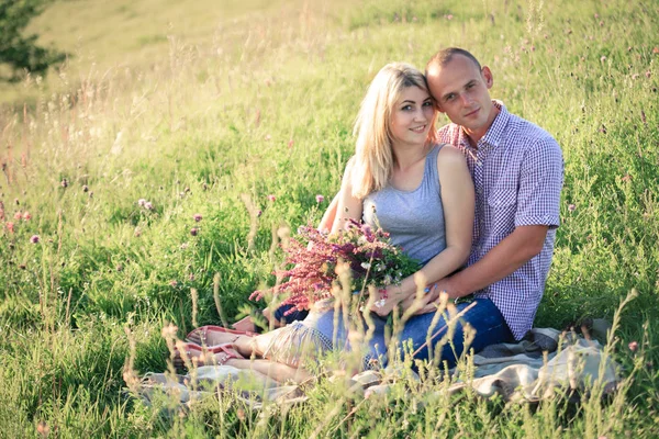 Man en vrouw op de natuur met een boeket bloemen. Paar verliefd. — Stockfoto
