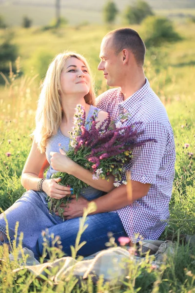 Homme et femme sur la nature avec un bouquet de fleurs. Couple amoureux . — Photo