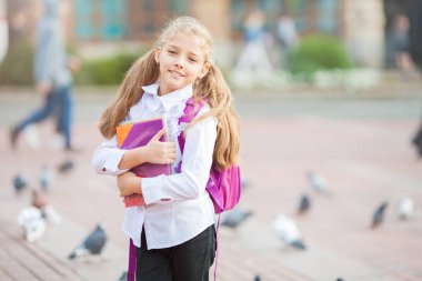 Kız öğrenci bir sırt çantası ve kitap açık havada. Eğitim ve öğrenme konsepti.