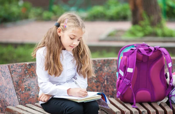 带背包的女学生,在户外看书。教育和学习理念. — 图库照片