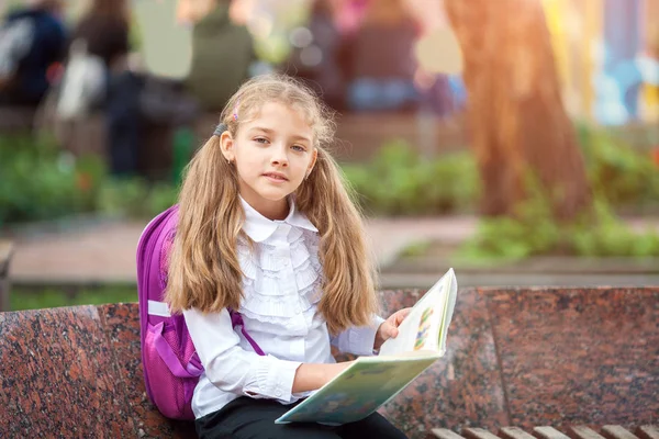 Schülerin mit Rucksack und Buch im Freien. Bildungs- und Lernkonzept. — Stockfoto