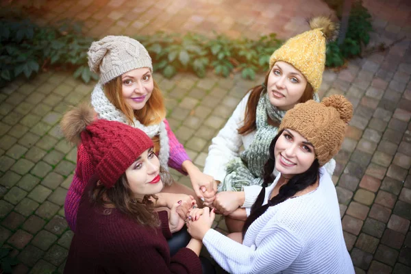 Meninas em roupas de malha quentes e chapéus abraço, vista superior. Dia de outono, um grupo de amigos . — Fotografia de Stock