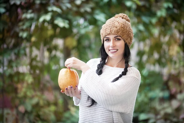 Happy lifestyle portrait of a beautiful young model woman with a pumpkin in her hands. — Stock Photo, Image