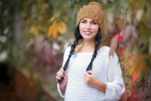 Retrato de estilo de vida feliz de uma bela jovem modelo com um sorriso em um chapéu de outono quente . — Fotografia de Stock