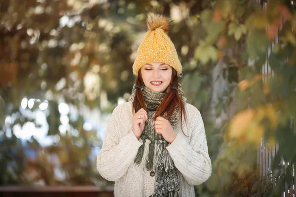 Happy lifestyle portrait of a beautiful young model girl with a smile in a warm autumn scarf. — Stock Photo, Image