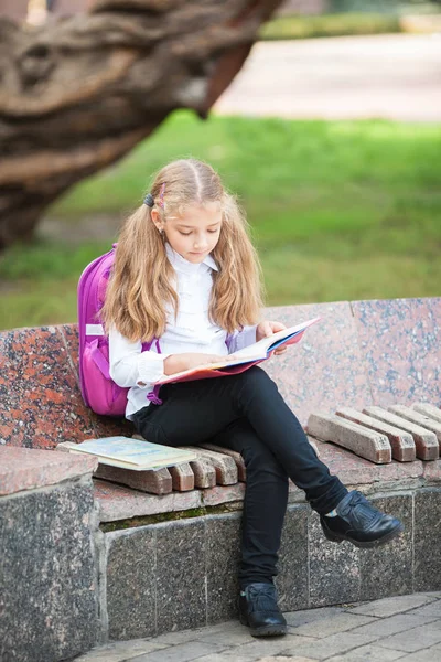 バックパックと屋外で本を持つ女子高生。教育と学習の概念. — ストック写真