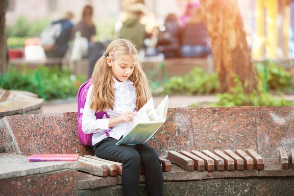 Schülerin mit Rucksack und Buch im Freien. Bildungs- und Lernkonzept. — Stockfoto