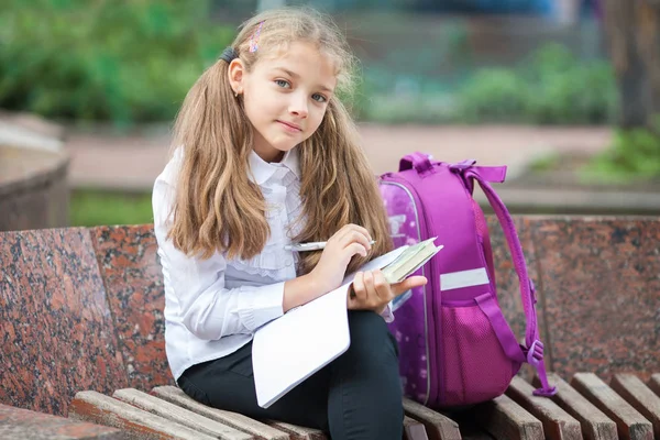 バックパックと屋外で本を持つ女子高生。教育と学習の概念. — ストック写真