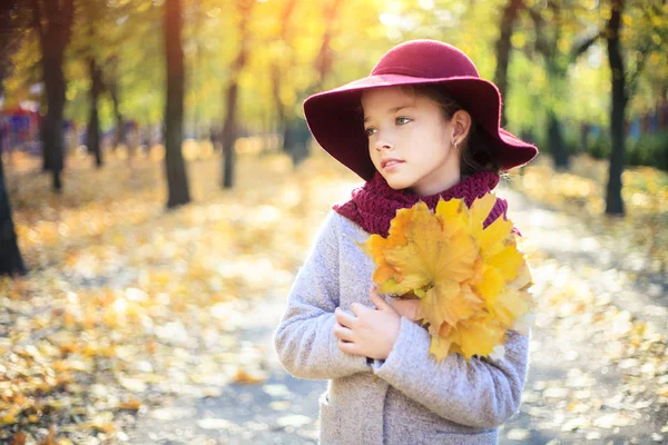 Dívka v klasickém kabátě a klobouku v podzimním parku. Podzimní sezóna, móda, dětství. — Stock fotografie