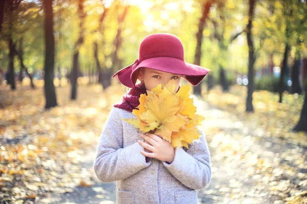 Dívka v klasickém kabátě a klobouku v podzimním parku. Podzimní sezóna, móda, dětství. — Stock fotografie