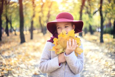 Sonbahar parkında klasik ceket ve şapka kız. Sonbahar sezonu, moda, çocukluk.