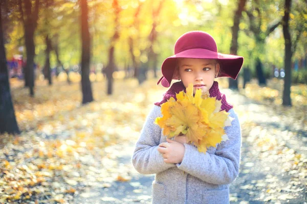 Dívka v klasickém kabátě a klobouku v podzimním parku. Podzimní sezóna, móda, dětství. — Stock fotografie