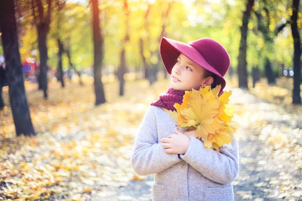 Dívka v klasickém kabátě a klobouku v podzimním parku. Podzimní sezóna, móda, dětství. — Stock fotografie